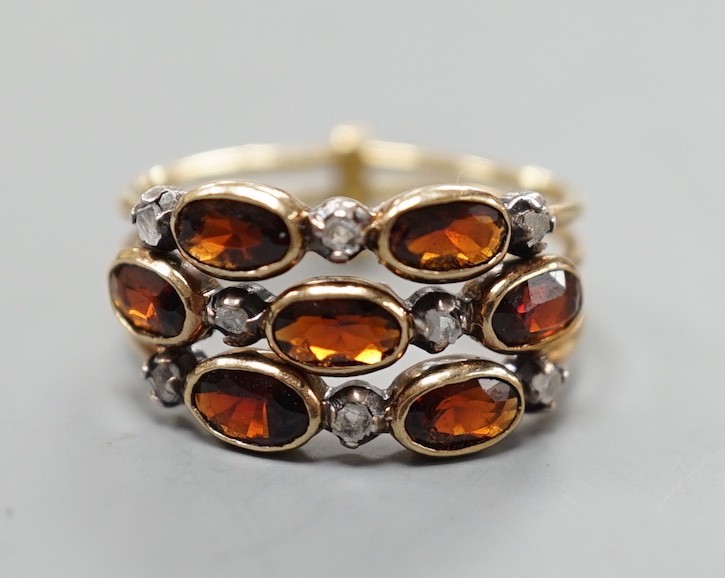 A late Victorian yellow metal, garnet and diamond chip cluster set triple shank ring, size M, gross weight 3.6 grams.